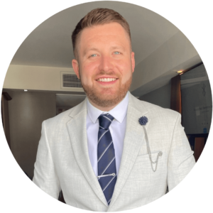 Recruitment CRM Review - Sam Jacobs - Manging Director - Market 36 Recruitment White middle aged man with cropped beard wearing a light suit with dark blue tie.